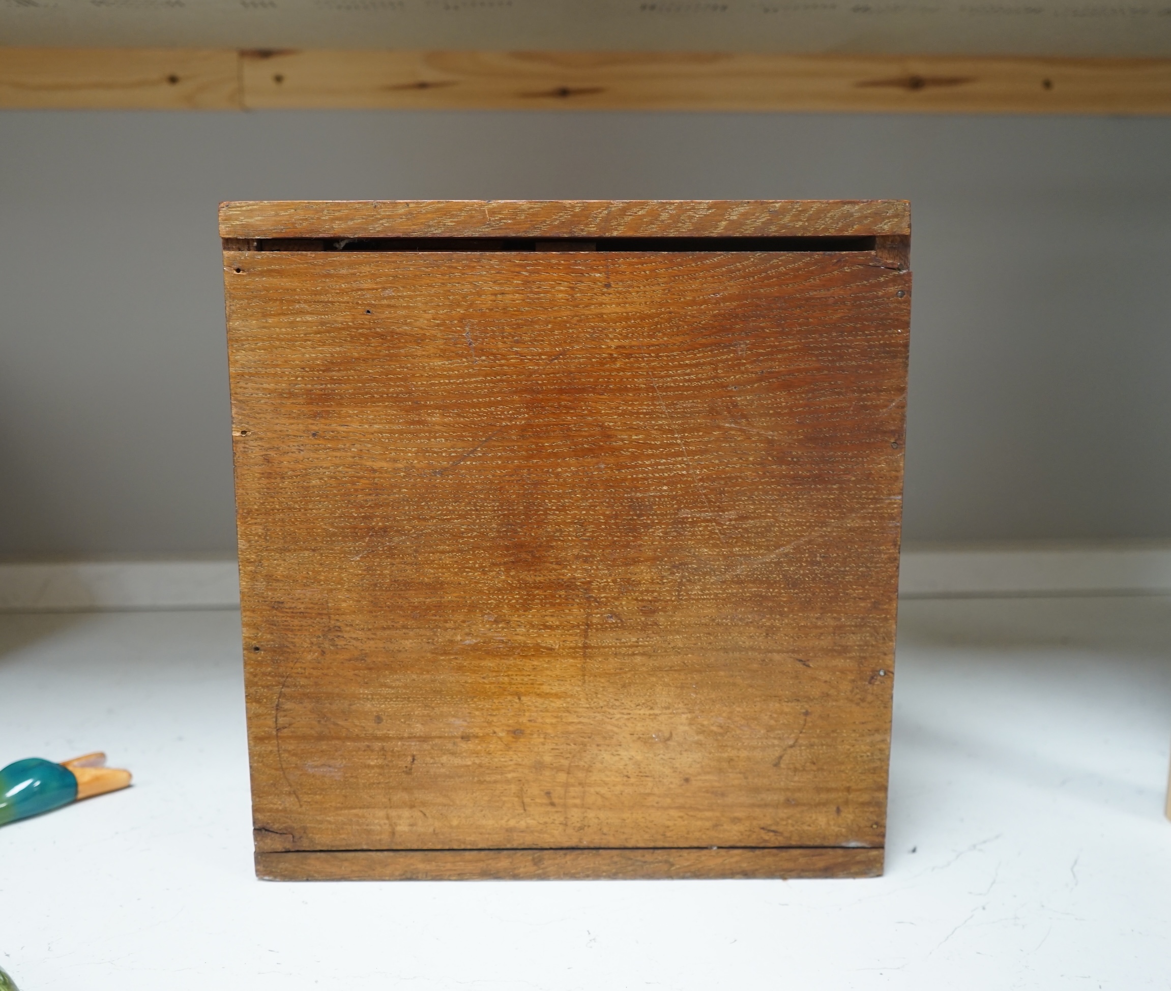 A Victorian oak cigar cabinet modelled as a safe, with brass coat of arms mounts, 30cm wide, 31cm high. Condition - fair